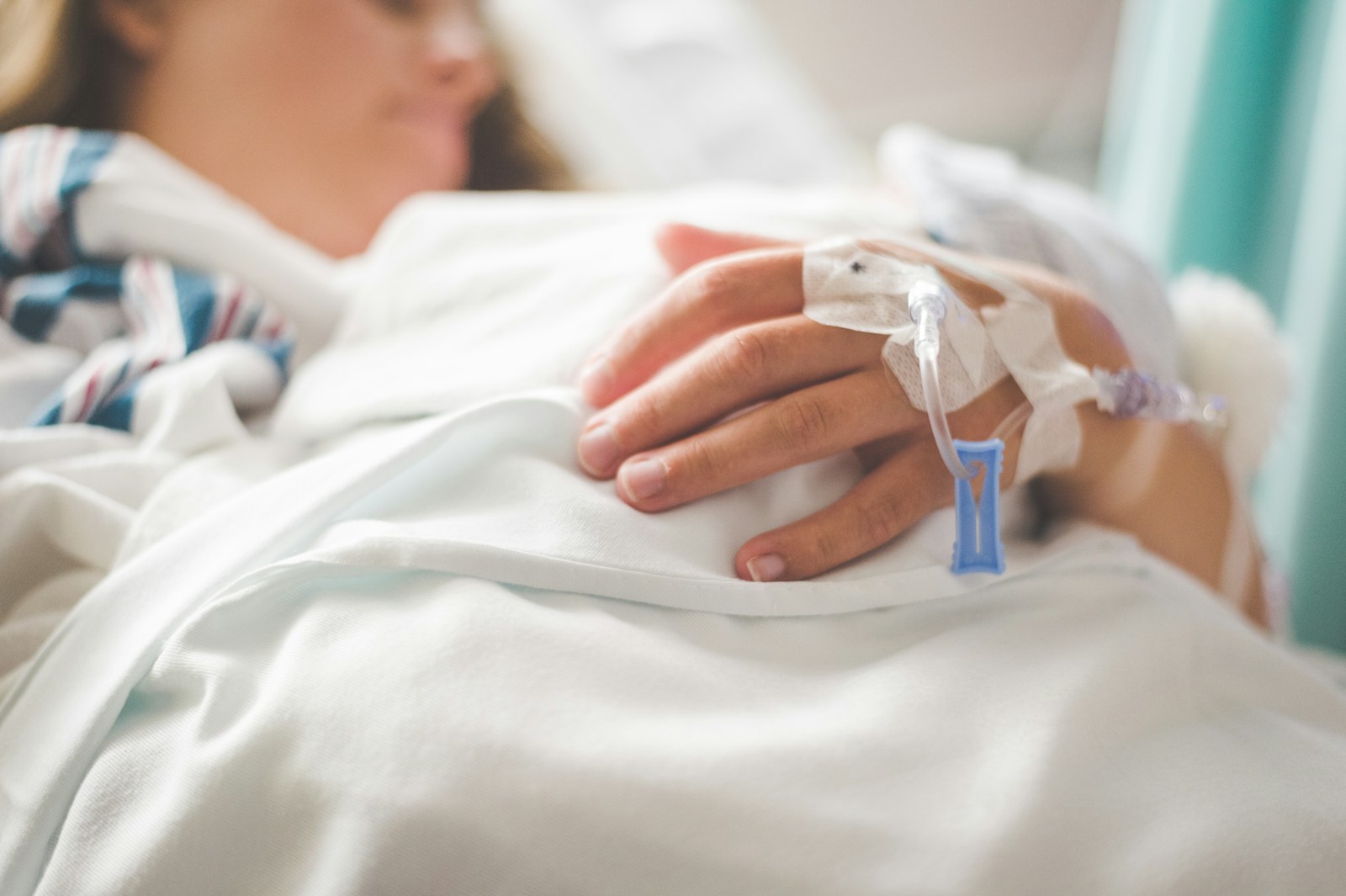 a woman laying in a hospital bed with an iv in her hand, medpay